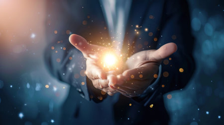 A man dressed in a suit is seen holding a glowing light in his hand, illuminating his surroundings. The light emits a soft, warm glow, casting shadows on the mans face and suitの素材