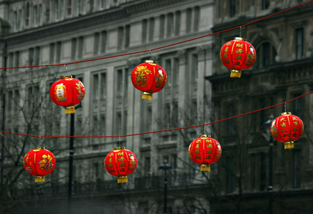 Seven red Chinese lanterns hanging on a rope with background of gray buildings during celebrations of Chinese new year in Londonの写真素材