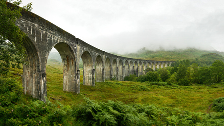 High resolution panorama of Glenfinnan railway viaduct  shot from side, on overcast day with grey sky and lot of green grass and trees around. Inverness, Scotlandの写真素材