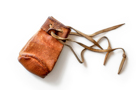 Small old worn brown leather coin pouch, isolated on white background.の写真素材