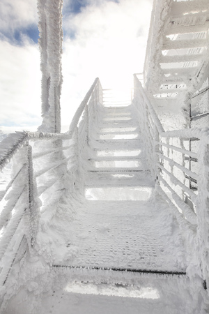 Stairs and rail, completely covered with ice crystals, strong sun back light in background. Freezing winter.の写真素材