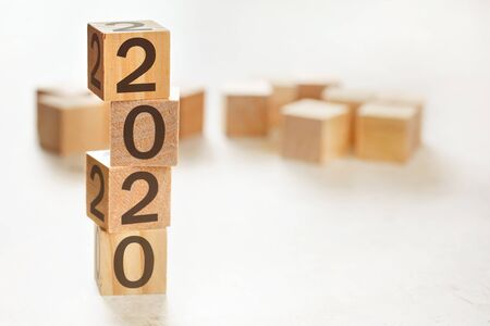 Four wooden cubes arranged in stack with text 2020 on them, space for text image at down right cornerの写真素材