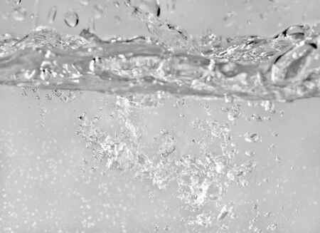 Water splashes as liquid is poured into the tank, abstract backgroundの写真素材
