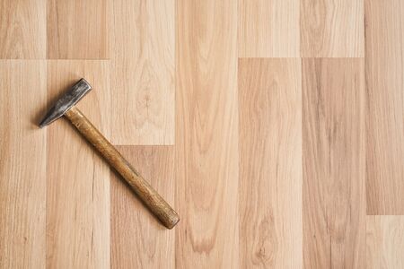 Hammer on laminated floor, view from above, space for text right side.の写真素材