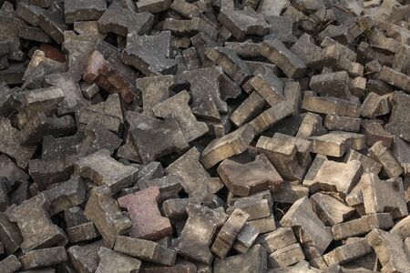Pile of discarded pavement (segmental paver) cobblestones.