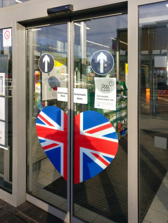 London, United Kingdom - March 31, 2020: Advise note informing about restrictions to number of people inside the supermarket at the entrance to Lidl branch in Lewisham during coronavirus outbreakのeditorial素材