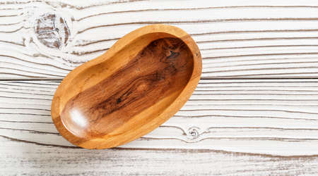 Small polished rosewood bowl on white boards desk, closeup view from aboveの写真素材