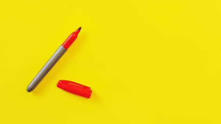 Top view on red marker, cap opened, on yellow board, copyspace for your text on right side.の写真素材