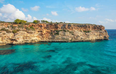 Clear blue green sea water, rocky cliffs around - nice sunny day at Ansa de sEstri, Mallorcaの写真素材