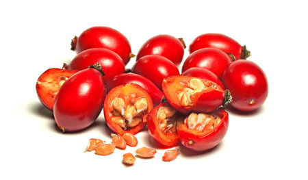 Rosehips Rosa Canina fruits , some cut in half seeds visible, isolated on white background.の写真素材