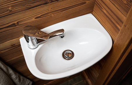 Small white wash basin, wooden walls around, closeup detailの写真素材