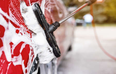 Red car washed in self serve carwash , detail on brush leaving strokes on side doorの写真素材