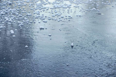 Ice on frozen lake with pieces of snow, close up detail - winter background.の写真素材
