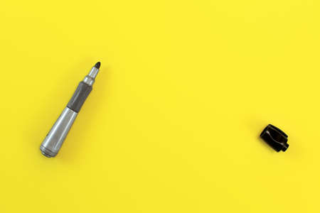 Thick black marker pen with opened cap on yellow board - space to write your text, view from above.の写真素材