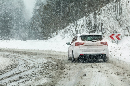 Vysna Boca, Slovakia - January 08, 2019: Car drives through heavy snowstorm on forest road, in sharp curve. Driving conditions are often dangerous in winter.のeditorial素材