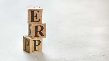 Pile with three wooden cubes - letters ERP meaning Enterprise Resources Planning on them, space for more text / images at right side.の写真素材
