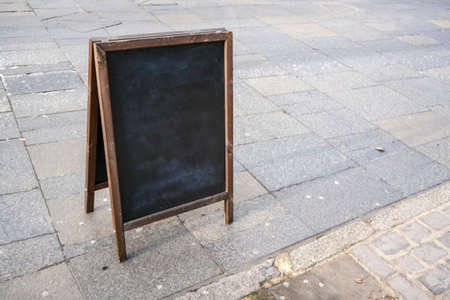 Empty blackboard on the street pavement. Mockup to add your own text.の写真素材