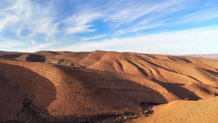 Panorama of hills with regular brown soil pattern in Tizin-Tinififft pass Ouaourmas Morocco, blue...