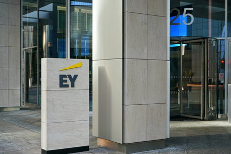 London, United Kingdom - February 03, 2019: Blue and yellow EY signage at entrance to their office in Canary Wharf. It is UK professional services company, one of big 4 accounting firmsのeditorial素材
