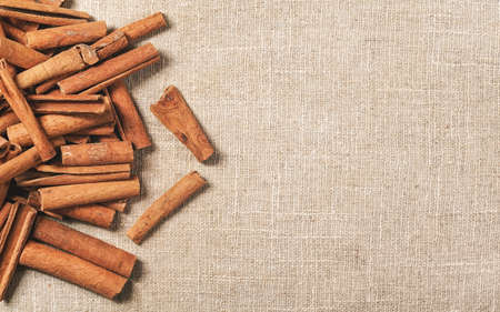 Top down view - Heap of cinnamon bark sticks on linen tablecloth, space for text on right sideの写真素材