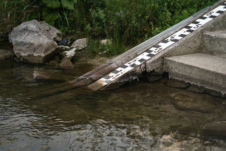 Scale at shore of river to measure water level, which is very low on this photoの写真素材