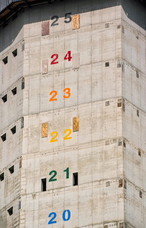 Tall modern skyscraper construction, concrete walls with numbers marking floors to be builtの写真素材
