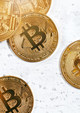 Top down view, golden commemorative btc - bitcoin cryptocurrency - coins scattered on white stone board, closeup detailの写真素材