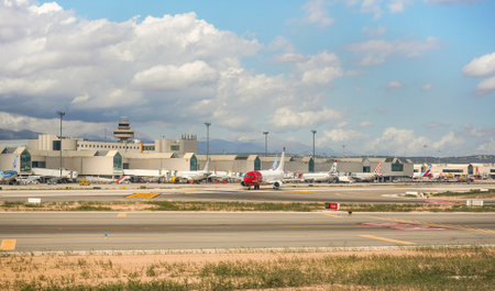 Palma, Spain - September 25, 2019: Various airlines aircrafts parked in front of airport building on sunny day, runway in foregroundのeditorial素材