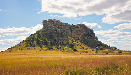 Low grass growing on African savanna, small rocky mountains in background - typical scenery at Isalo national Park, Madagascarの写真素材