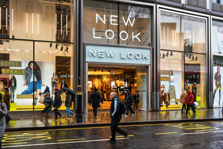 London, United Kingdom - February 01, 2019: Pedestrians walk in front of New Look store branch at Oxford Street on a rainy day. It is British fashion shop founded 1969のeditorial素材