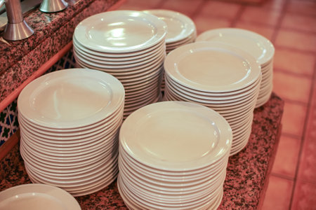 Clean white plates ready at table in buffet restaurant