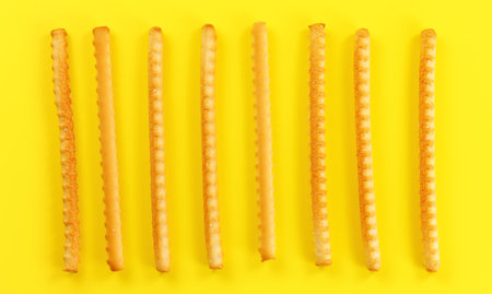 Grissini, also known as breadsticks on yellow board, view from aboveの写真素材
