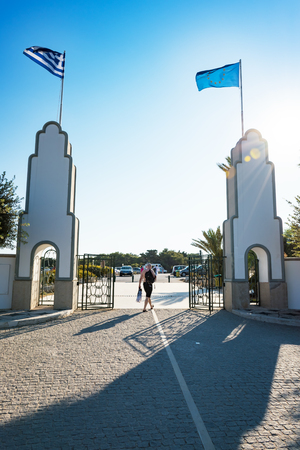 Man walking in between the columns with flags in Kallithea (Rhodes, Greece)のeditorial素材