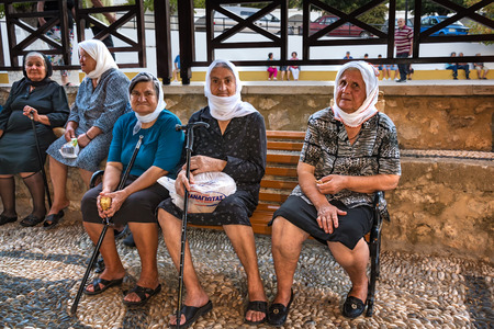 TSAMBIKA, RHODES ISLAND, GREECE â SEPTEMBER 6 2017:  Old Greek unknown women sit on the bench and enjoy afternoon near Tsambika monasteryのeditorial素材