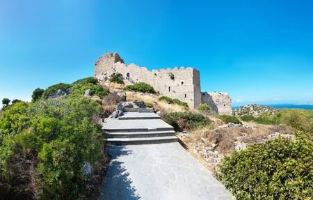 Stairs through bushes to ruins of medieval castle Kritinia with sea in backgraound (Rhodes, Greece)のeditorial素材