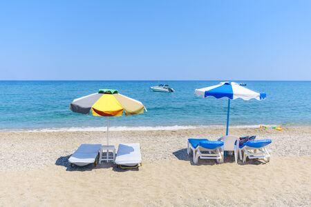 Empty sunbeds with umbrellas on Stegna beach (RHODES, GREECE)の写真素材