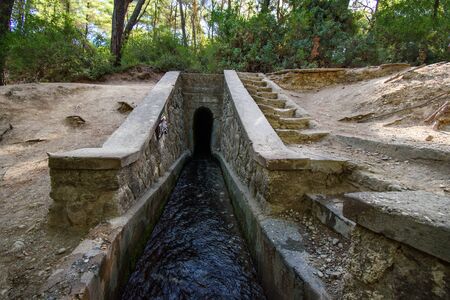 Entrance to tunnel on Loutanis river in Seven spring (Epta Piges) in forest near Kolymbia (Rhodes, Greece)の写真素材