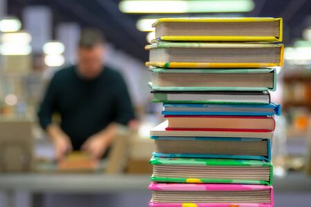 Stack of books on blurred background of bookstore. The concept of education and knowledge from books. Close up. With space for your text or logo.の写真素材