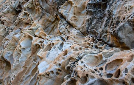 Texture, background layers and cracks in sedimentary rock on cliff face. Cliff of rock mountain. Rock slate in the mountain. Seamless abstract background. Cracks and layers of sandstoneの写真素材