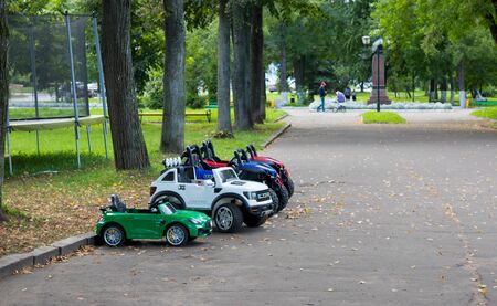 Cute little baby girl playing with blue small toy car in garden of home or nursery. Adorable beautiful toddler child with blossoming magnolia on backgroundの写真素材