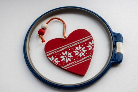 Red heart fabric with white threads on white background, isolated. The concept of Sadness, unhappy...