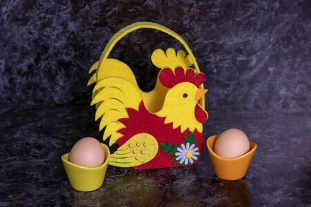 Easter basket filled with colorful eggs on a dark background.の写真素材