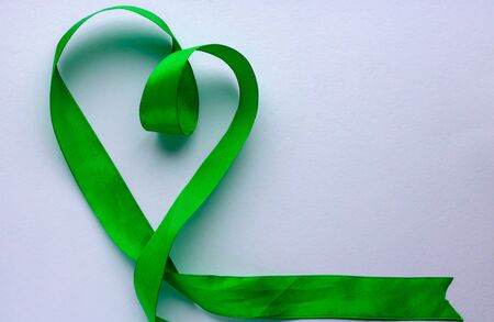 Green ribbon in a shape of heart on white background. love concept. Christmas day concept.Valentine day.presentの写真素材