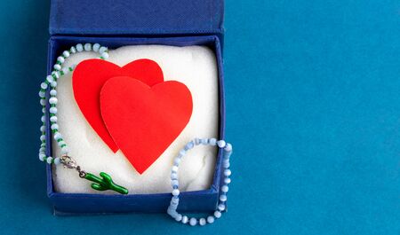 A blue opened gift box on a blue background with red paper hearts. Valentines day concept. Space for text. presentの写真素材