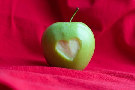 Perfect fresh green apple isolated on red background.の写真素材
