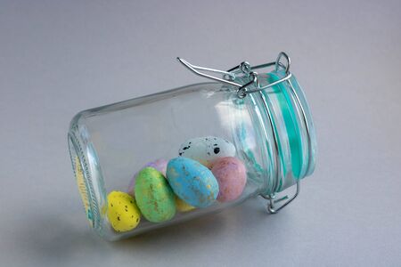 a jar of colorful easter eggs in a jar with copy space. easter concept