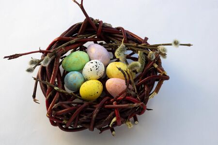 a nest of willow twigs and colorful eggs