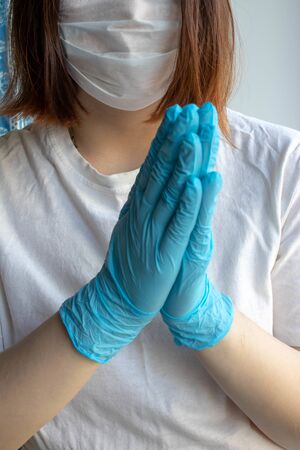 Hands in blue protective gloves, medical mask on the face. Coronavirus, the concept COVID-19.の写真素材