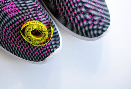 Lilac sneakers with a centimeter on the side on a white background.Space for text
