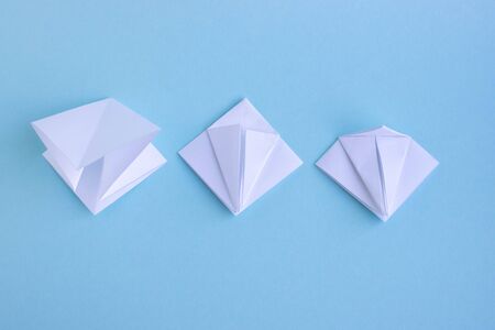 Handmade white trendy geometric polygonal paper origami fish on blue background.Step 2. Horizontal poster.の写真素材